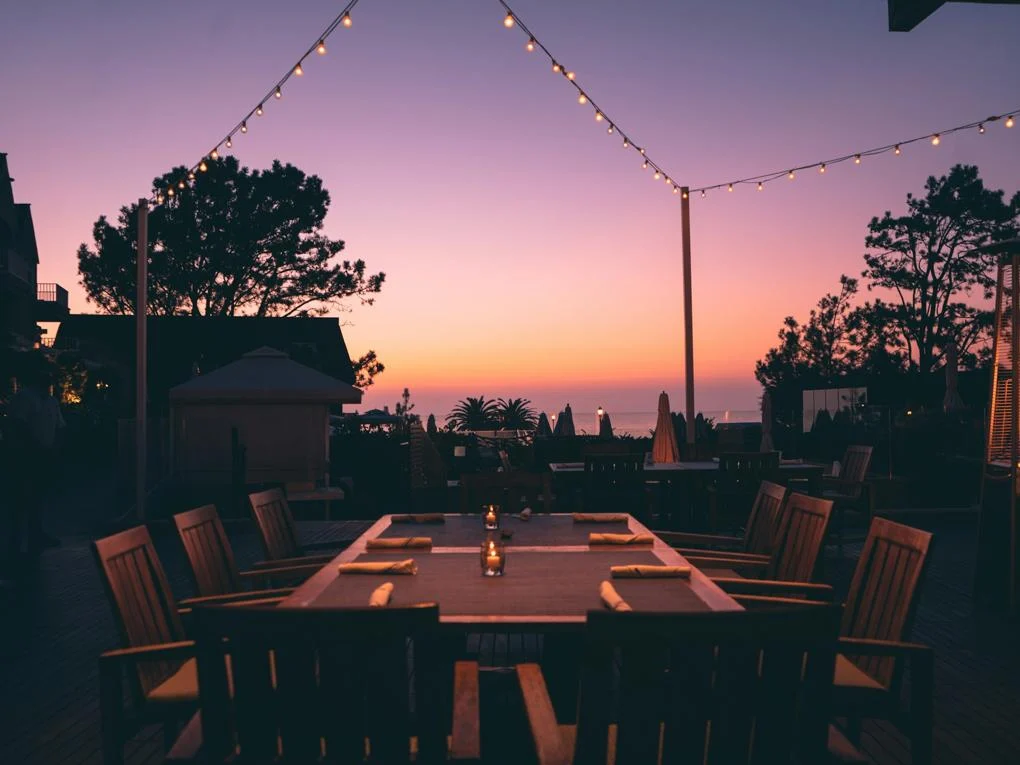An outdoor dining table underneath a purple dusk sky