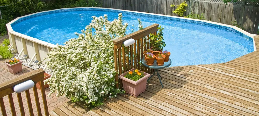 above ground swimming pool with deck and flowers decor