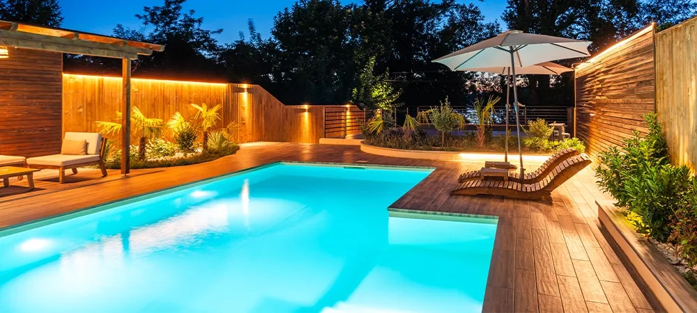 modern pool with illuminated seating area at night. Concept of luxurious evening relaxation and outdoor ambiance