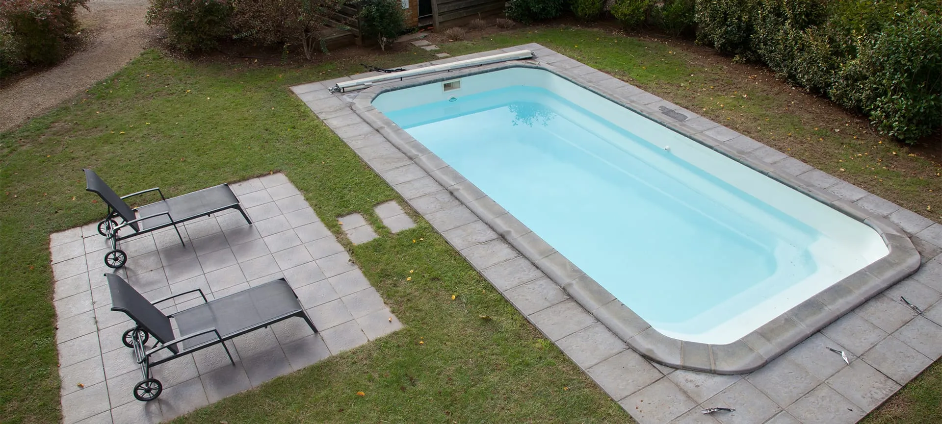 pool concrete deck with landscape and sitting space
