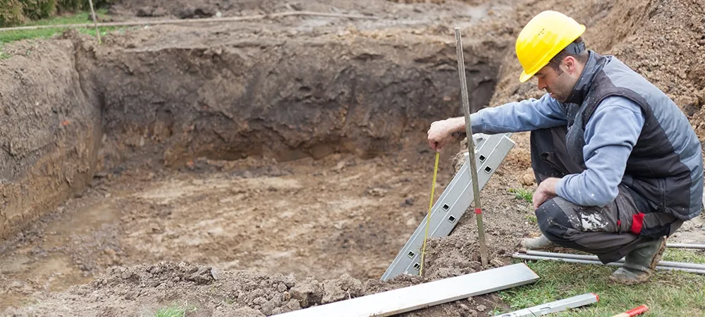 pool contractor inspecting soil digging for pool space