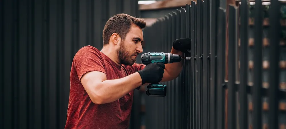 man installing aluminium outdoor fence