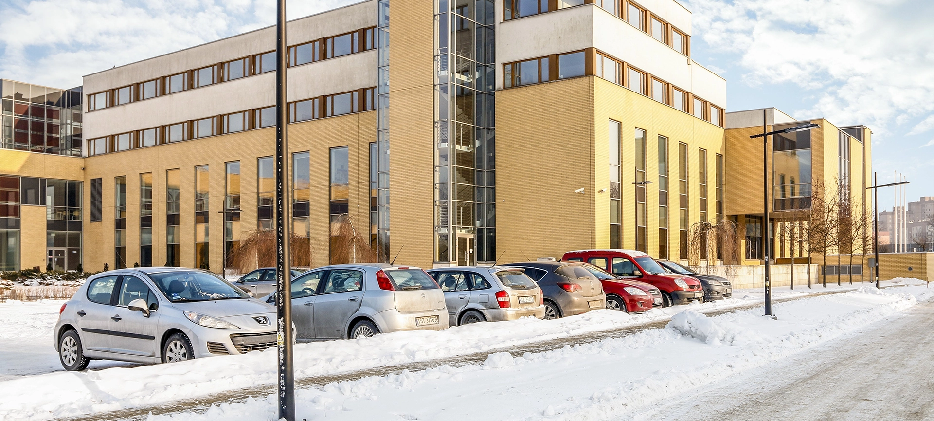 modern office building on bright winter day, snow covered parking area
