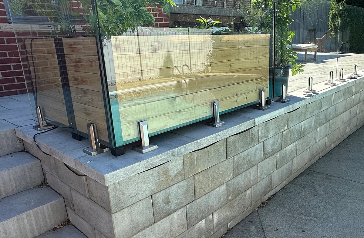 concrete block patio and step with glass railing