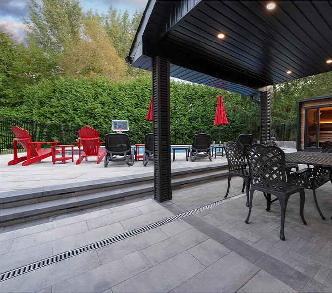 interlocking backyard patio with pool and sitting setup and water drainage