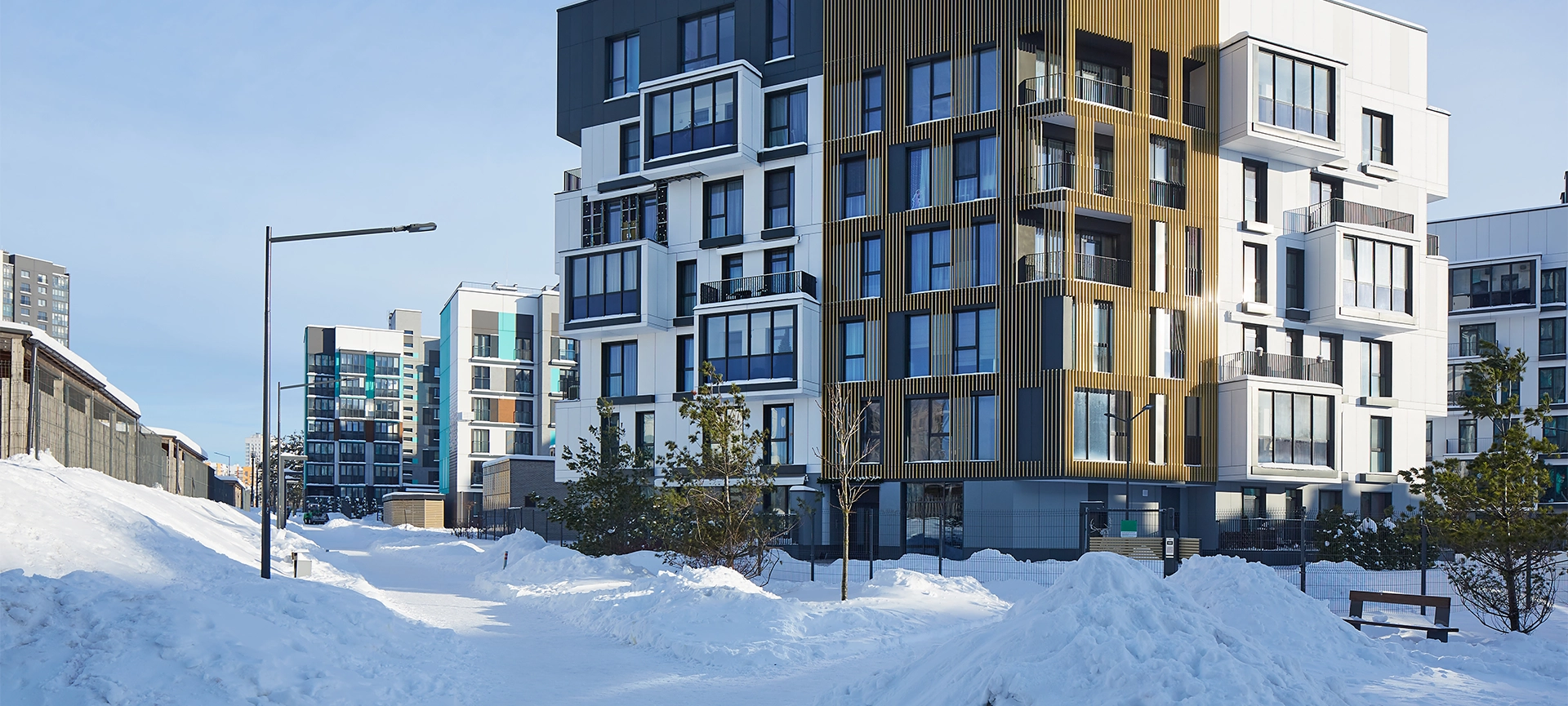 New modern block of flats in green area at winter. residential apartment with flat buildings exterior. luxury house complex covered snow. condo