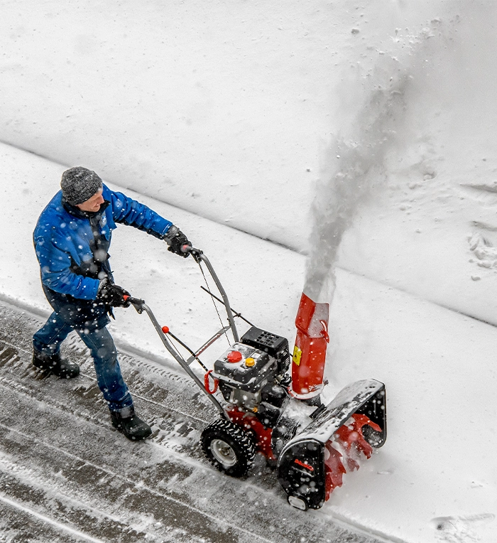 man removing snow from road using snow plow