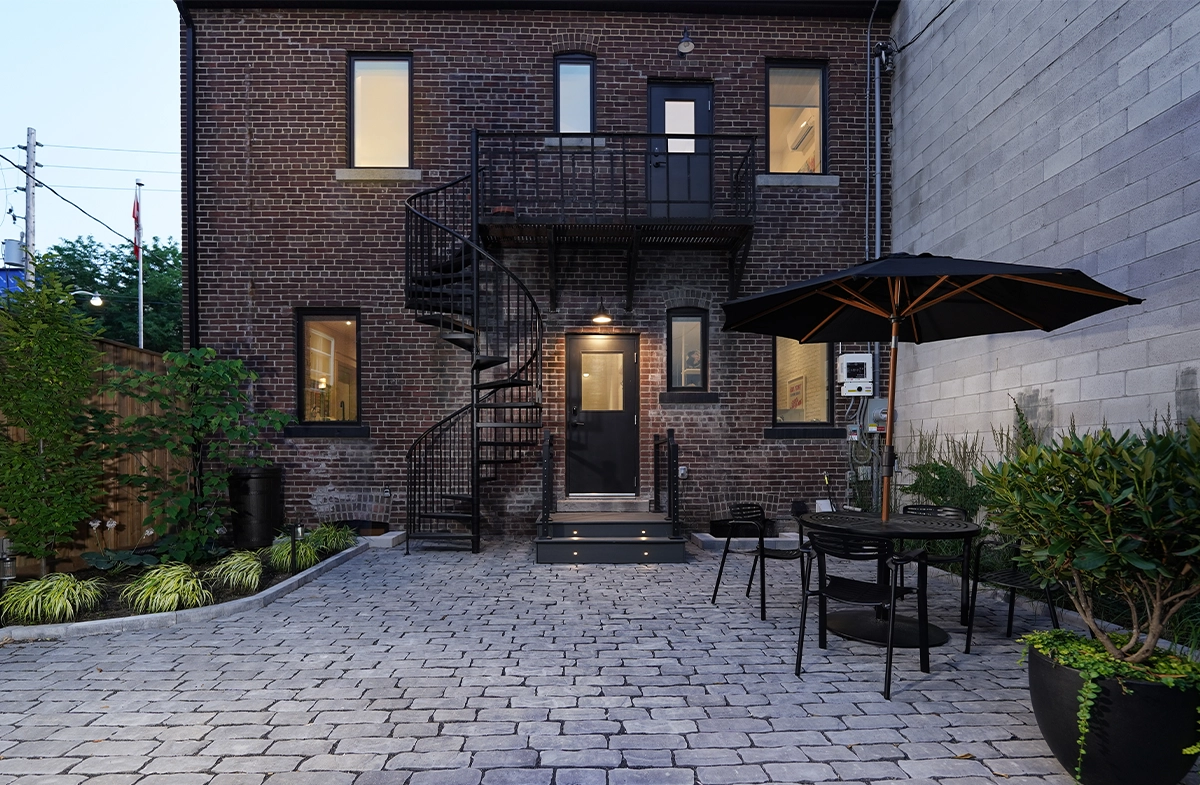 night view of brick made building and open paver floor with landscaping night view of brick made building and open paver floor with landscaping