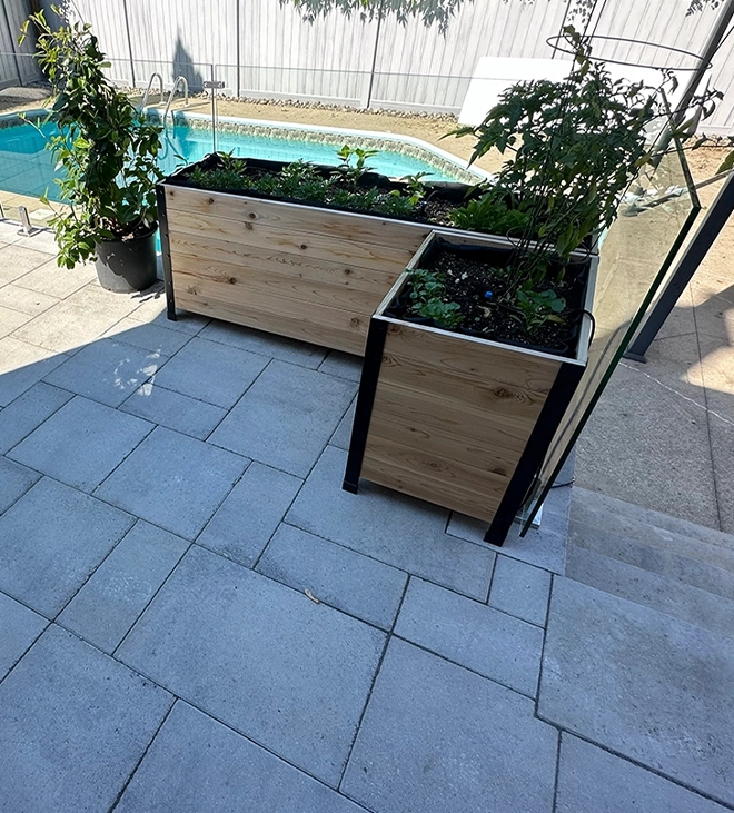 planting pots on interlock patio beside glass railing