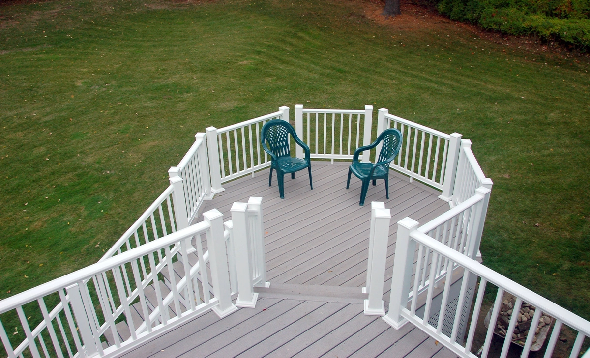 timbertech deck with railings and stairs toward backyard lawn