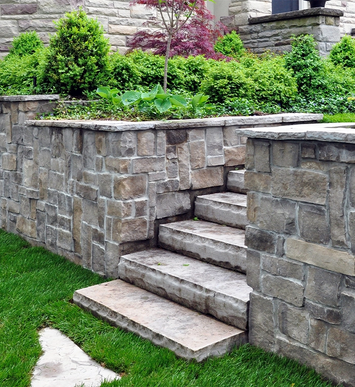 armour stone retaining wall with steps in yard