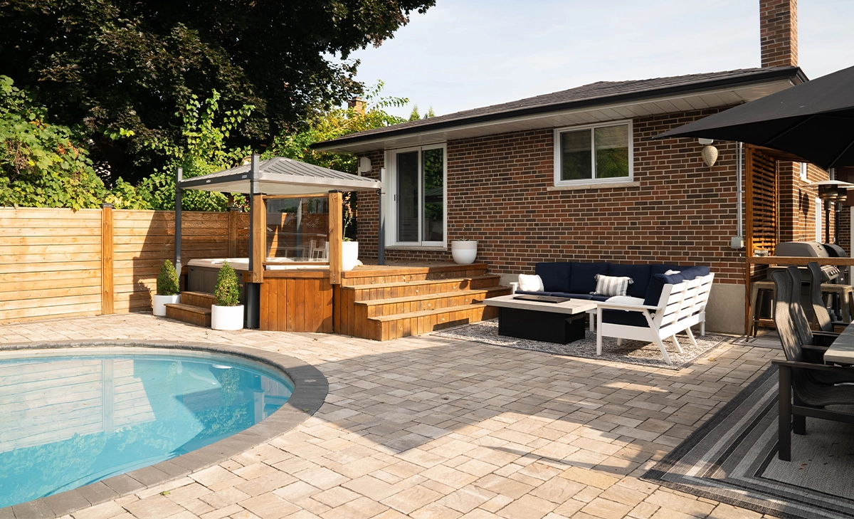 backyard interlocking surface around pool , plunge and sitting setup