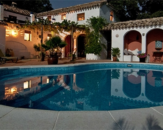 concrete pool and deck night view at residential building back side
