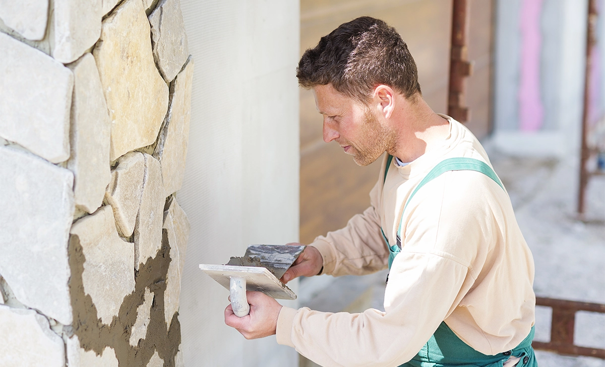 expert craftsman installing natural stone wall