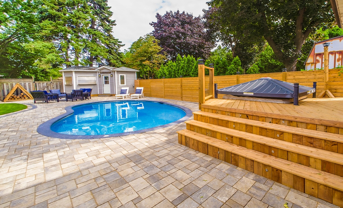 custom pool deck custom pool deck, interlocking surface, custom carpentry and wooden fence in backyard