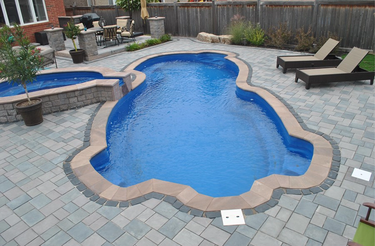 fiberglass pool with interlocking pool coping and deck, full yard view
