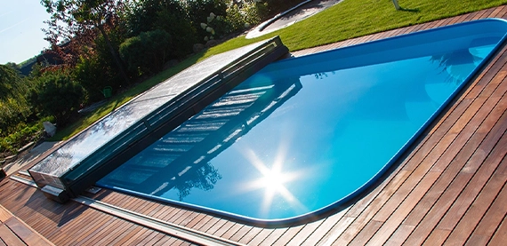 fibreglass pool with wooden deck and pool cover in garden yard