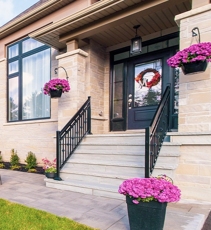 residential building front door interlocking steps with railing and decor flower in pots