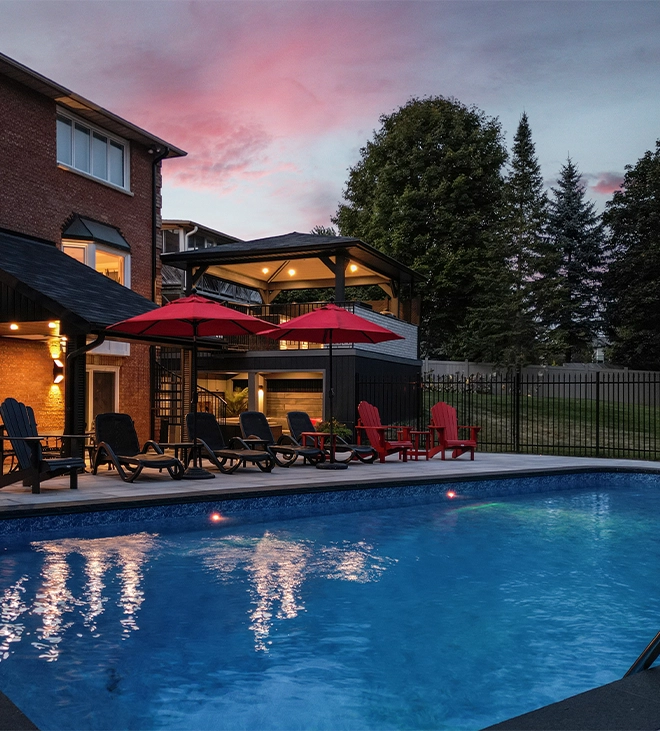 light feature in concrete pool, backyard view, custom carpentry and sitting setup on interlock deck