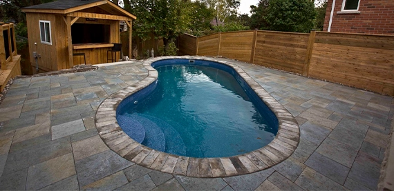 pool with customize interlocking surface and wooden carpentry with fence
