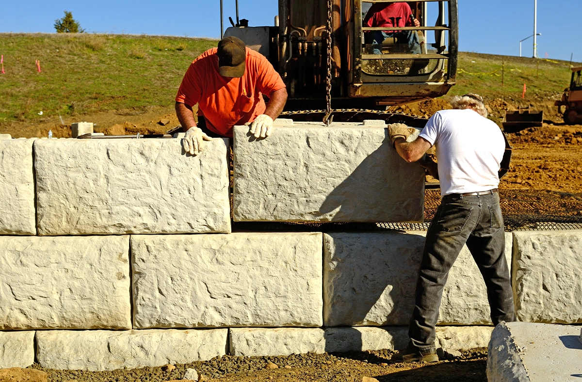 professional team installing interlocking blocks retaining wall, large traditional interlocking blocks