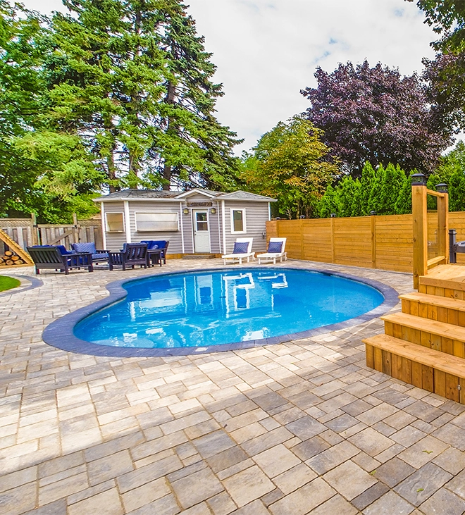 interlocking surface around pool interlocking surface around pool and backyard space, custom carpentry storage room, sitting setup, wooden deck, fence and landscaping