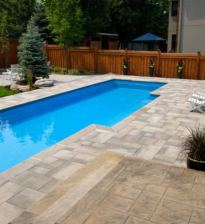 large pool with interlocking surface in backyard