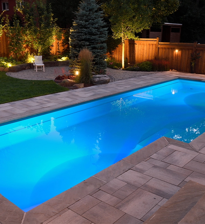 lighting feature in large fibreglass pool and landscaping in backyard space