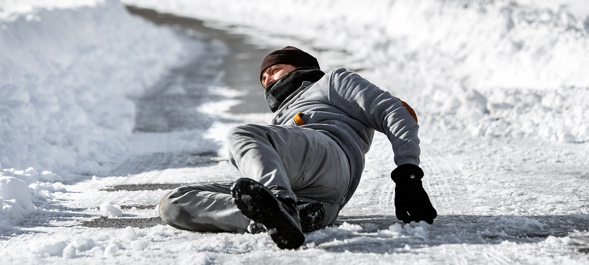 Injured man lying on the road, downfall and accident on winter season, black ice