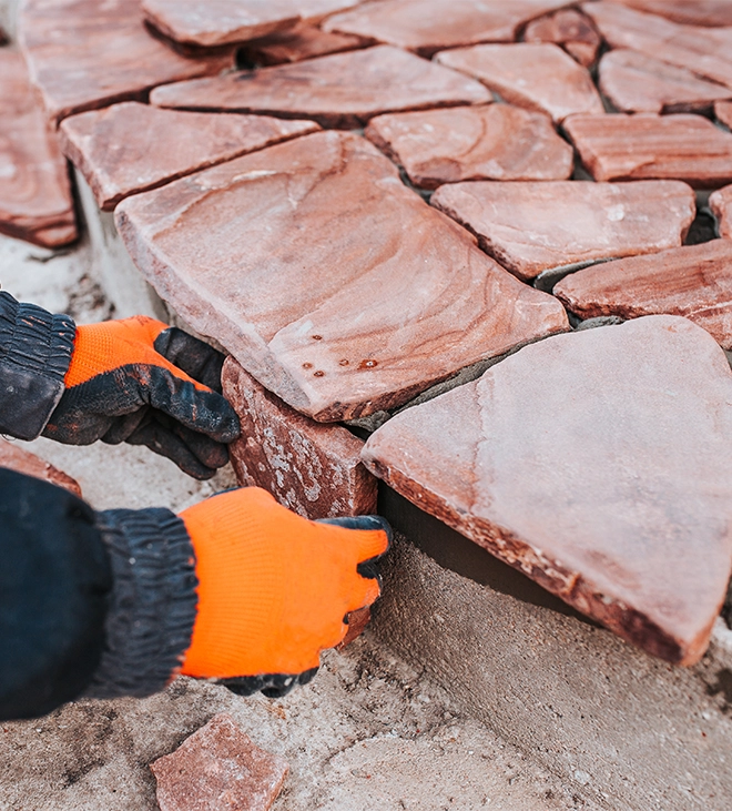 man installing natural stones on surface