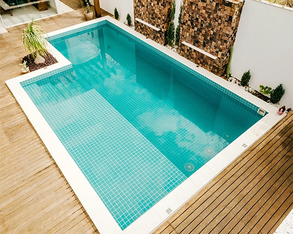 small swimming pool with pool coping and wooden deck top view