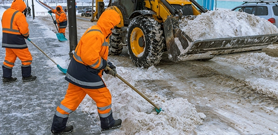 snow removal team clearing snow from road