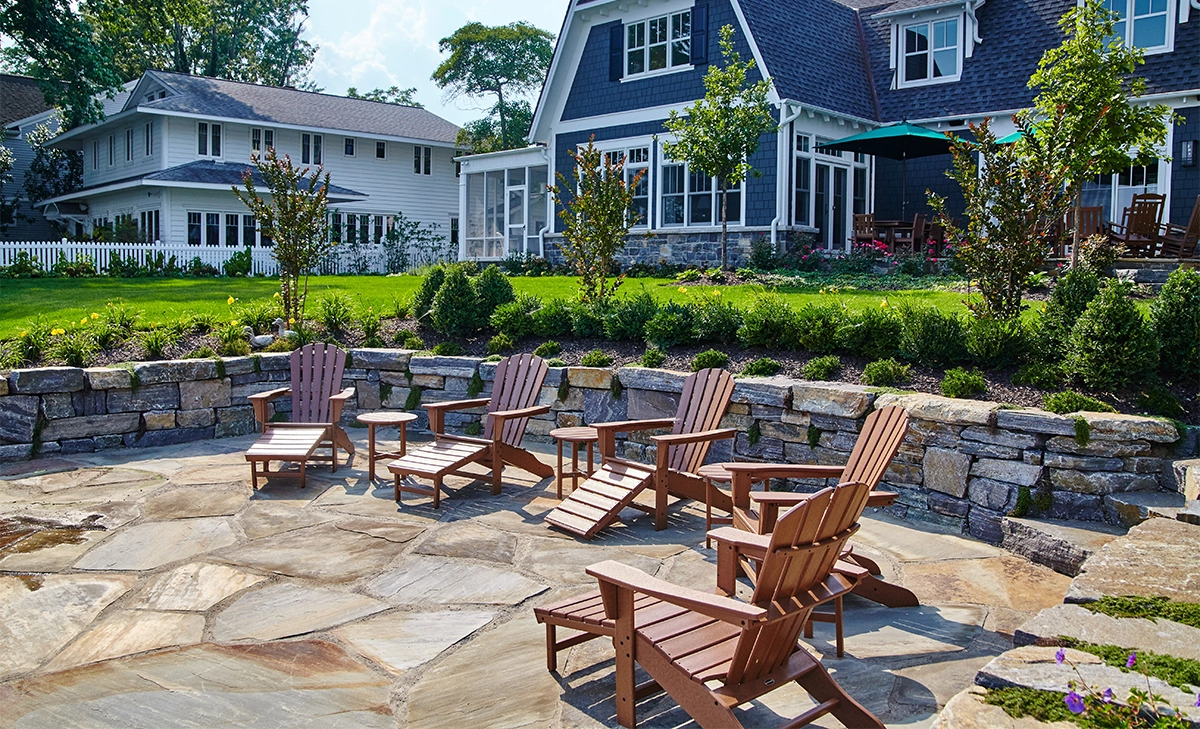 small armour stone retaining wall small armour stone retaining wall and yard with chairs in front of residential building