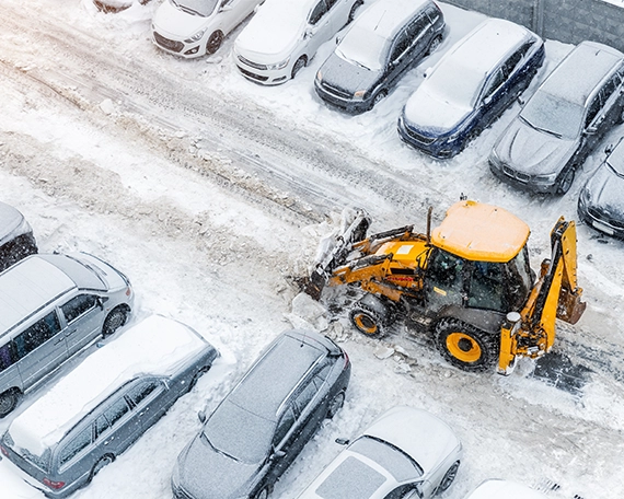 tractor removing snow from parking road