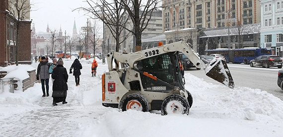 snow removal tractor on road side clearing walkway