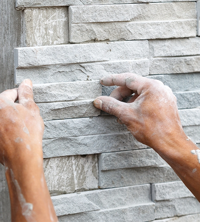 man installing stone wall