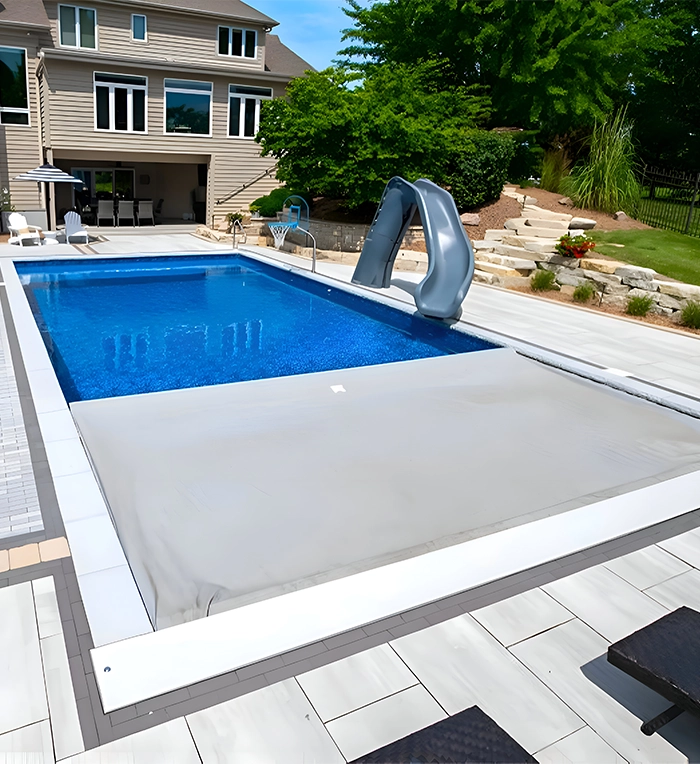 automatic pool cover on swimming pool in home backyard