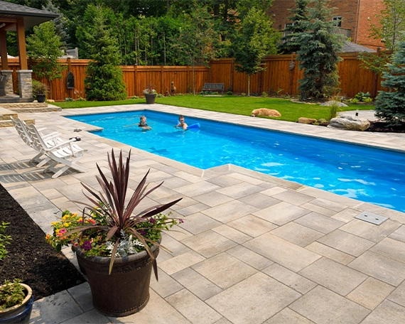 vinyl pool img three family enjoying in vinyl pool, interlocking deck around pool
