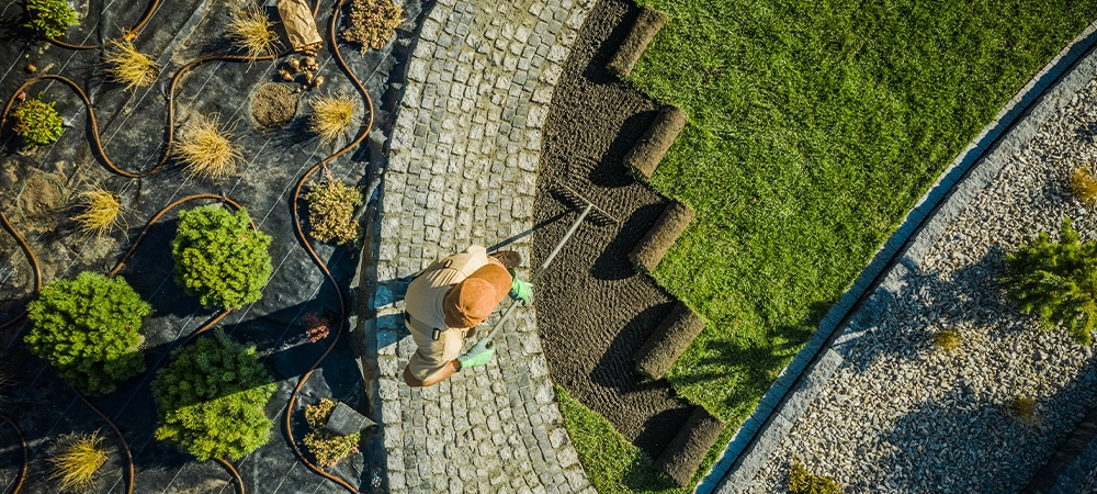 Professional Landscaper Installing Natural Grass Turfs in Newly Developed Residential Backyard Garden. Aerial View.