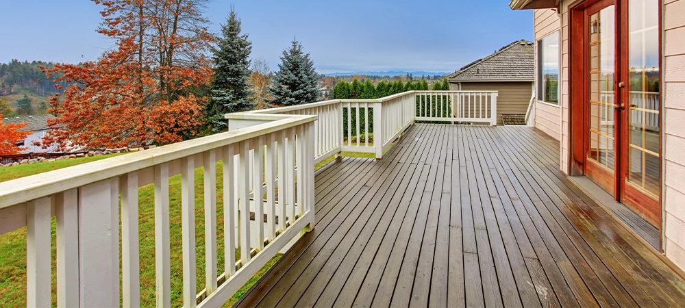 Beautiful large backyard with deck, lots of grass, and a view.