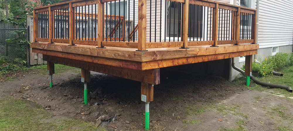 pressure treated wood deck and railing with Deckorators black aluminum balusters. steel shafts helical piles