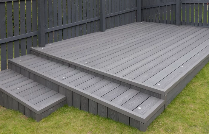 Ash grey composite decking built on two levels on a residential back garden with low voltage deck lights installed as well. Good Image for a landscape Gardiner