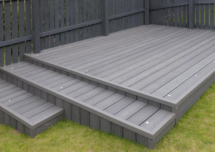 Ash grey composite decking built on two levels on a residential back garden with low voltage deck lights installed as well. Good Image for a landscape Gardiner